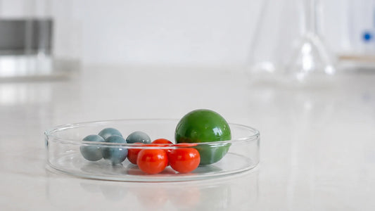 Une poignée de billes de verre dans un petit bocal transparent, posé sur un plan de travail clair.