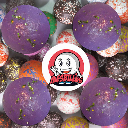 Collection de billes en terre multicolores avec plusieurs billes violet paillettes 22 mm au premier plan, ambiance élégante et vintage